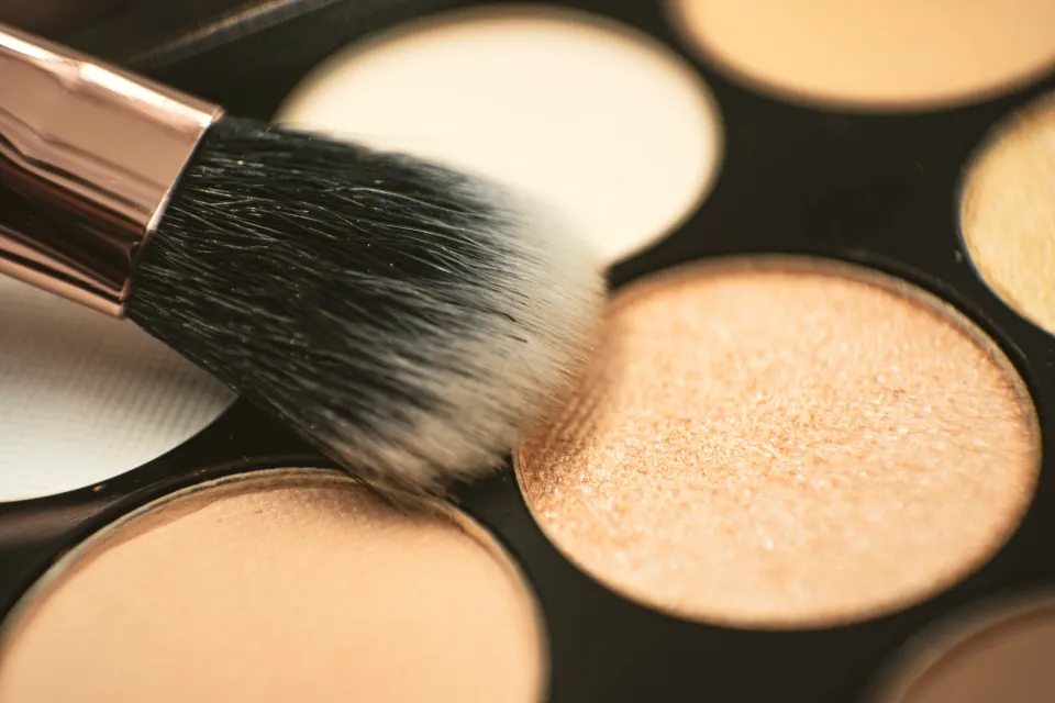 A make-up brush dipped in a shimmery eyeshadow palette