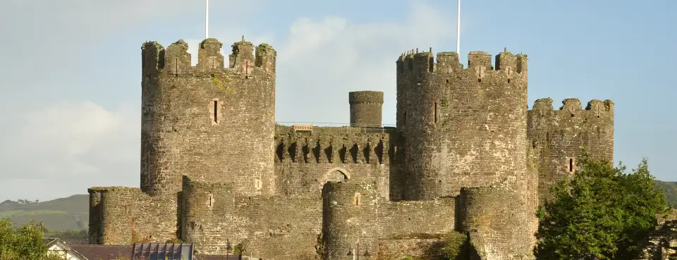 The towers of Conwy Castle with Welsh flags flying